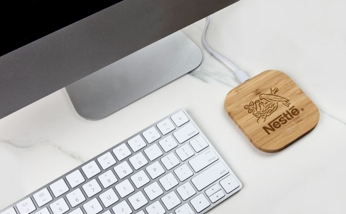 Bamboo wireless charger on a desk with a computer