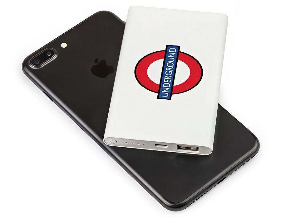 A white power bank lying on a mobile phone