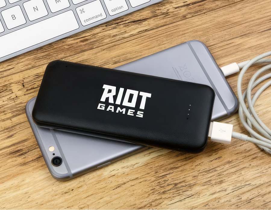 A black power bank charging a smartphone